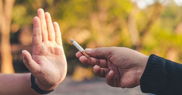 Main refusant une cigarette : installer durablement les bienfaits de l’arrêt du tabac grâce à l’hypnose